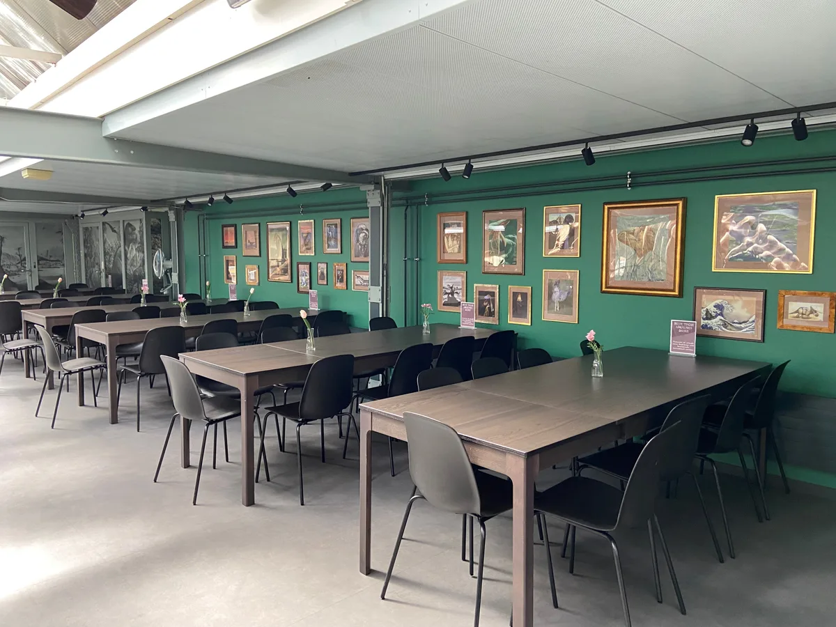 Das neue Café im Sauriermuseum mit Tischen, Stühlen und Bildern an den Wänden.